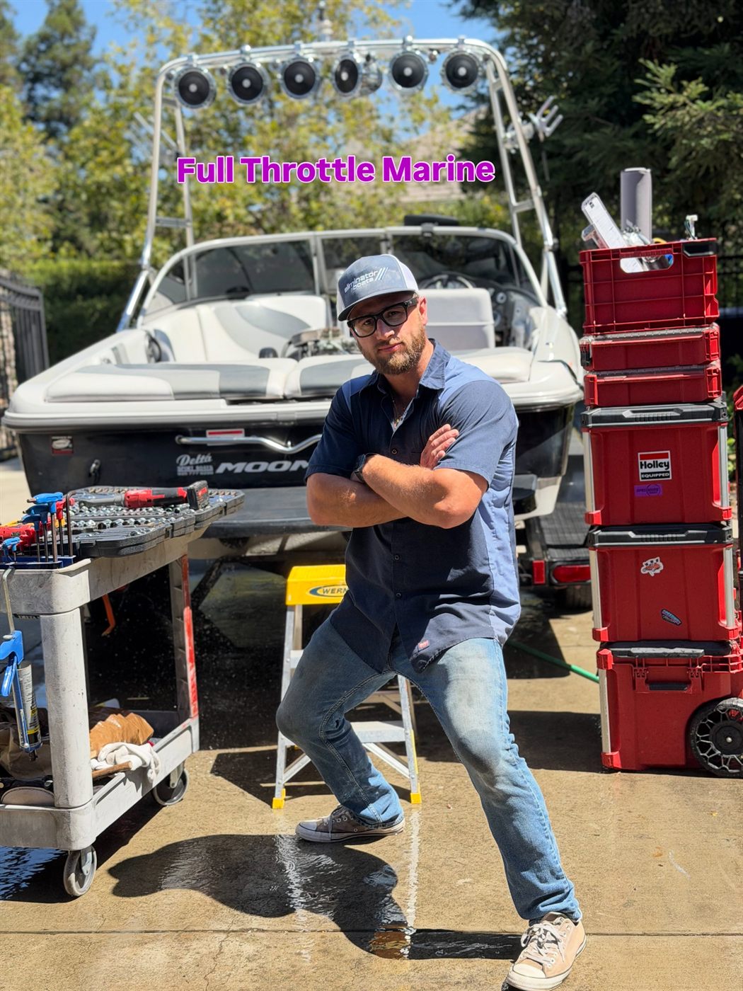 Full Throttle Marine mechanic in front of a Moomba wake boat with tool carts and equipment cases.